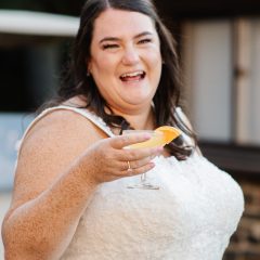 Bride holding a cocktail during wedding reception by Seedling and Sage Catering
