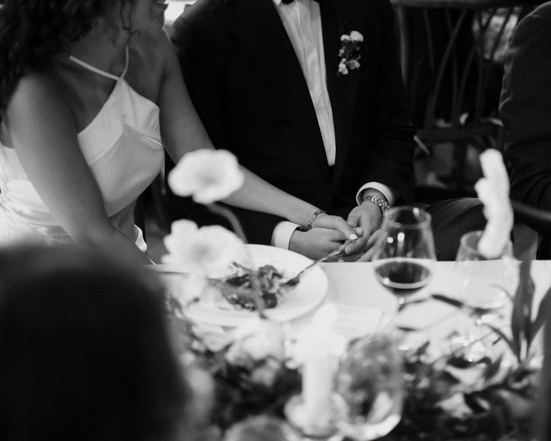 Couple sitting hand in hand at wedding reception dinner in Philadelphia